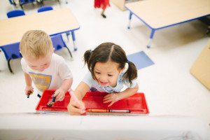 Montessori teacher guiding a child in a hands-on learning activity.