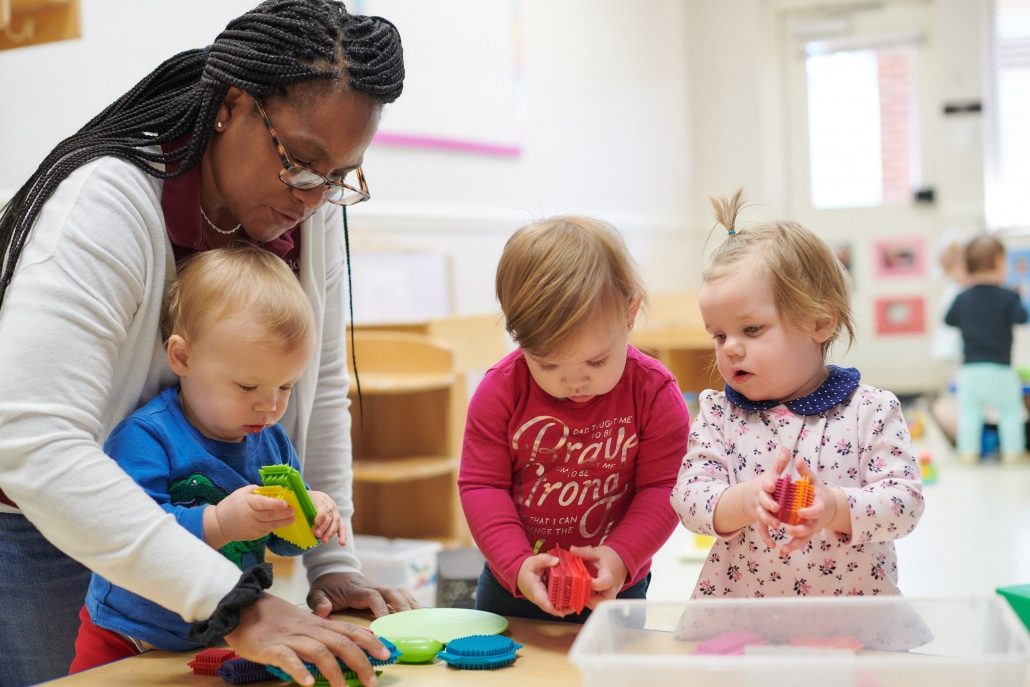 Montessori teacher guiding a child in a hands-on learning activity.